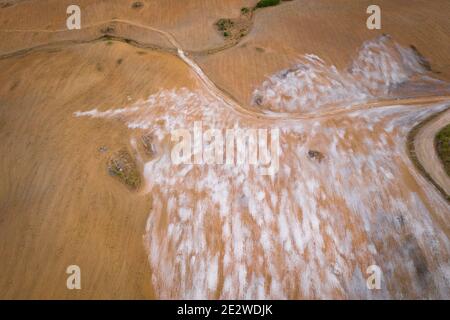 Panorama aereo in cima al drone di un deserto come un paesaggio collinare con pietre di marmo polvere al tramonto a Terena vicino a una diga lago serbatoio, Portogallo Foto Stock