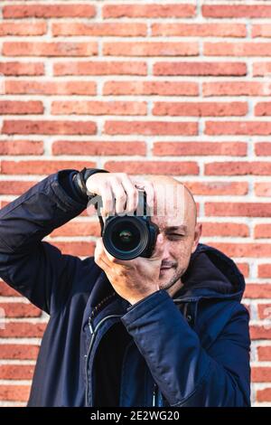 Uomo che fotografa guardando la sua macchina fotografica che posa sorridendo Foto Stock
