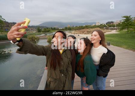 Un gruppo di belle donne prende un selfie in parco del centro città vicino a. Foto Stock