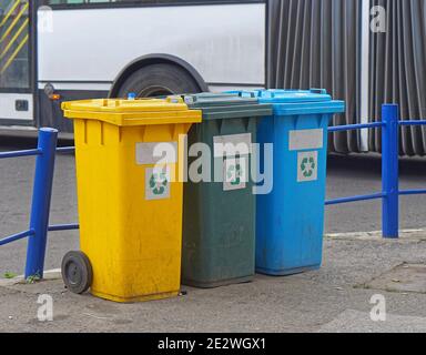 Tre bidoni di riciclaggio e smistamento in plastica per strada Foto Stock