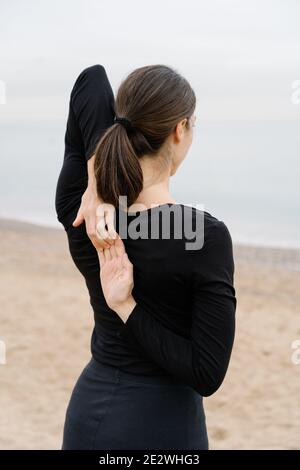 Donna che fa esercizi con le mani sulla schiena. Foto Stock