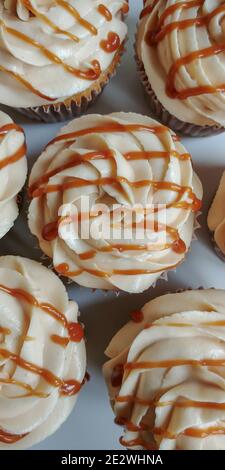 Vista dall'alto di cupcake cremosi sgocciolati con salsa al caramello Foto Stock