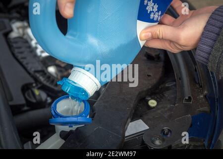 aggiunta di liquido lavaparabrezza invernale nella vettura Foto Stock