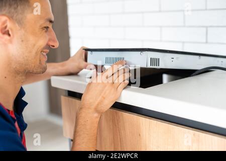 Installazione di fornelli a induzione piano di cottura o da parte di un maestro. Foto Stock