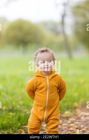 Ritratto del ragazzino in tute gialle nel parco Foto Stock