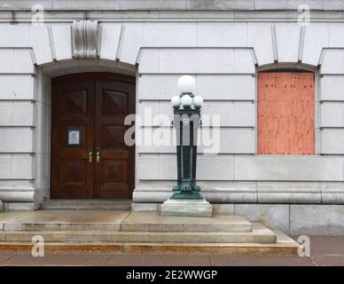 Madison, Wisconsin, Stati Uniti. 15 gennaio 2021. I preparativi sono in corso presso e nei pressi del Campidoglio di Stato a Madison, Wisconsin venerdì 15 gennaio 2021 in caso di violente proteste legate all'insediamento del Presidente eletto Joseph R. Biden e del Vice Presidente eletto Kamala Harris. Le finestre del primo piano dell'edificio sono salite e le barriere stradali vengono installate attraverso tutte e quattro le strade che conducono all'edificio. Un piccolo gruppo di persone, guidato da una donna che porta una bandiera americana e prega il Rosario, marciò intorno e intorno al Campidoglio, pregando per la pace. (Immagine di credito: © Mark Hertzb Foto Stock