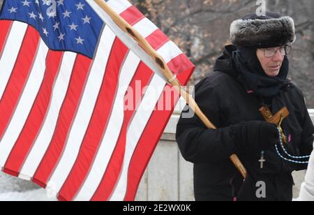 Madison, Wisconsin, Stati Uniti. 15 gennaio 2021. I preparativi sono in corso presso e nei pressi del Campidoglio di Stato a Madison, Wisconsin venerdì 15 gennaio 2021 in caso di violente proteste legate all'insediamento del Presidente eletto Joseph R. Biden e del Vice Presidente eletto Kamala Harris. Le finestre del primo piano dell'edificio sono salite e le barriere stradali vengono installate attraverso tutte e quattro le strade che conducono all'edificio. Un piccolo gruppo di persone, guidato da una donna che porta una bandiera americana e prega il Rosario, marciò intorno e intorno al Campidoglio, pregando per la pace. (Immagine di credito: © Mark Hertzb Foto Stock