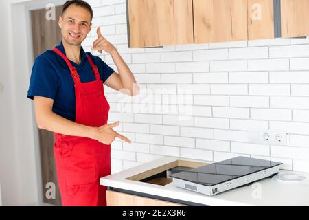 Installazione di fornelli a induzione piano di cottura o da parte di un maestro. Foto Stock