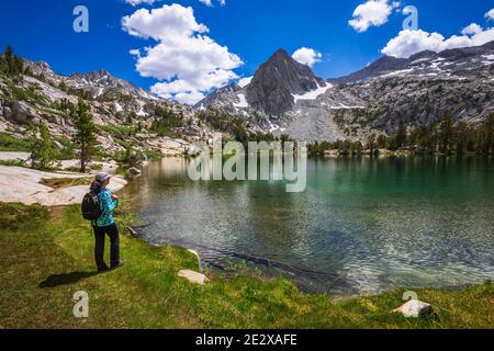 Escursionista sulla riva del Treasure Lake, John Muir Wilderness, Sierra Nevada Mountains, California USA Foto Stock