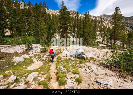Backpacker sul sentiero Treasure Lakes sopra South Lake, John Muir Wilderness, Sierra Nevada Mountains, California USA Foto Stock