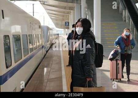 Suzhou.China-Gen.2021: Scatto medio del viaggiatore cinese sulla piattaforma della stazione ferroviaria, in maschera facciale per prevenire il coronavirus durante il Festival di primavera Foto Stock