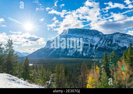 Banff National Park splendido paesaggio. Monte Rundle valle di montagna con verde e giallo alberi foresta in autunno neve soleggiato giorno. Foto Stock