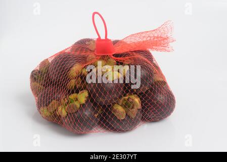 Mangosteen frutta in busta maglia 1 chilo fondo bianco, frutta famosa della Thailandia Foto Stock