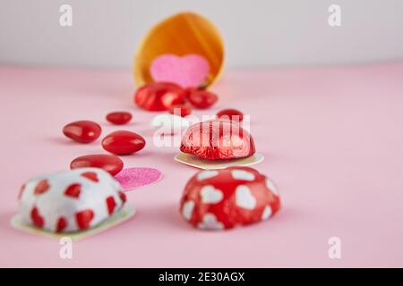 Carta di San Valentino con cuori di caramelle su sfondo cono gelato su sfondo rosa. Messa a fuoco selettiva. Foto Stock