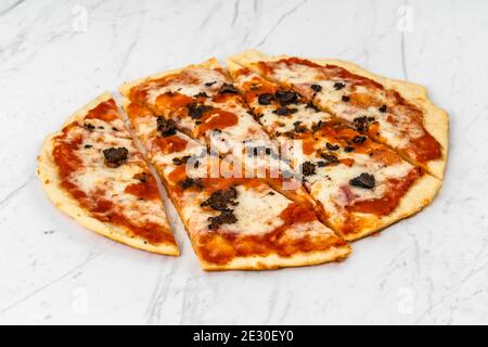 Pizza a fette, funghi al tartufo con salsa di pomodoro e formaggio su sfondo in marmo bianco Foto Stock