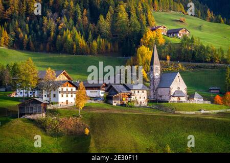 Vista della caratteristica chiesa e della città di San Magdalena. Val di Funes, Alpi Dolomiti, Trentino Alto Adige, Italia. Foto Stock