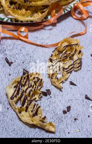 chatter o bugie, una torta di carnevale ricoperta di cioccolato fondente Foto Stock