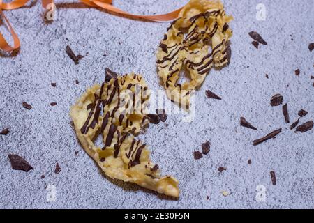 chatter o bugie, una torta di carnevale ricoperta di cioccolato fondente Foto Stock