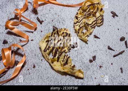 chatter o bugie, una torta di carnevale ricoperta di cioccolato fondente Foto Stock