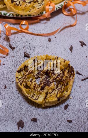 chatter o bugie, una torta di carnevale ricoperta di cioccolato fondente Foto Stock