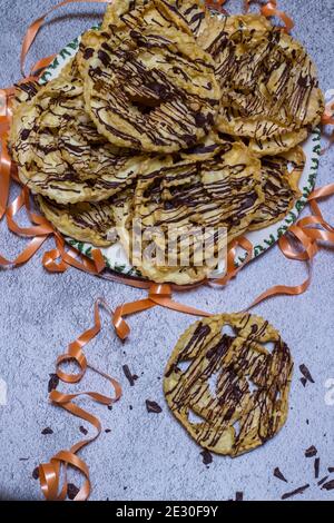chatter o bugie, una torta di carnevale ricoperta di cioccolato fondente Foto Stock