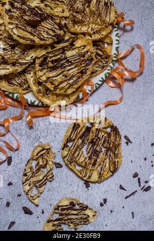chatter o bugie, una torta di carnevale ricoperta di cioccolato fondente Foto Stock