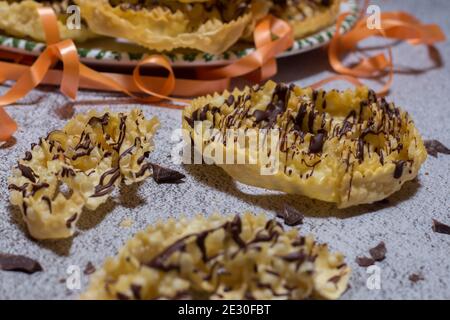 chatter o bugie, una torta di carnevale ricoperta di cioccolato fondente Foto Stock