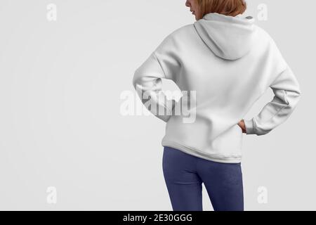 Serie di abiti mockup. Bella donna gracile in una felpa bianca con cappuccio e pantaloni blu isolato sullo sfondo vuoto studio.posa posteriore. Il modello può essere utilizzato in y Foto Stock