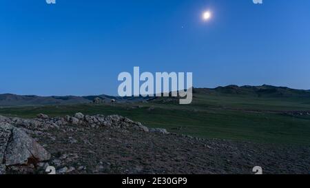 Camper nella steppa della Mongolia di notte con luna e cielo limpido. Foto Stock