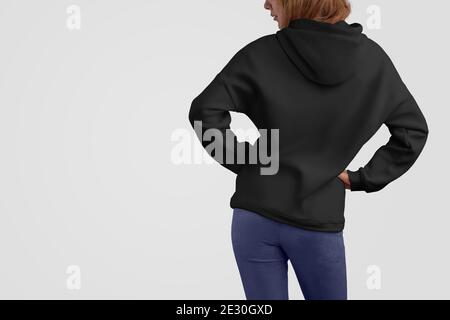 Serie di abiti mockup. Bella donna gracile in una felpa con cappuccio nera e pantaloni blu isolato sullo sfondo vuoto studio.posa posteriore. Il modello può essere utilizzato in y Foto Stock