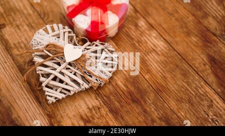 Rose rosse e bianche e cuore bianco di San Valentino su sfondo di legno. Vista dall'alto con spazio per la copia Foto Stock