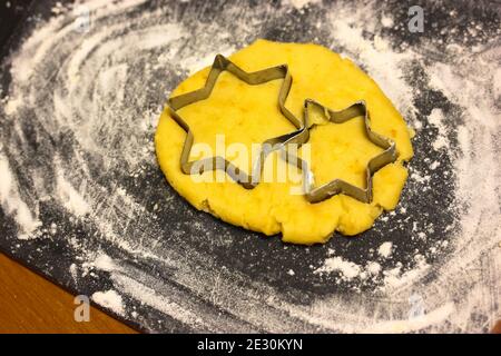 Taglierina a stella per biscotti con pasta, tagliere cosparso di farina Foto Stock