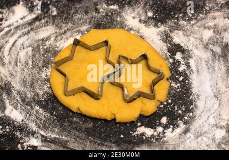 Taglierina a stella per biscotti con pasta, tagliere cosparso di farina Foto Stock