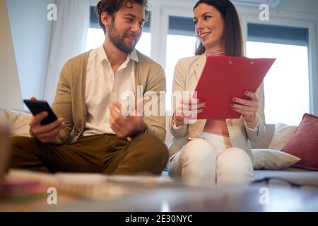 Giovani bei colleghi d'affari che hanno un bel colloquio ad una riunione in un'atmosfera amichevole in un appartamento. Affari, riunioni, persone Foto Stock