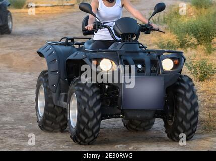 quad bike su strada sterrata (tutti i loghi, iscrizioni e contrassegni rimossi) Foto Stock