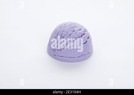 Colpo di closeup di una deliziosa tazza di gelato al mirtillo isolato su una superficie bianca Foto Stock