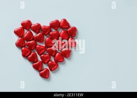 Cuore di cioccolato rosso di dolci su sfondo blu. Biglietto d'auguri per San Valentino. Foto Stock