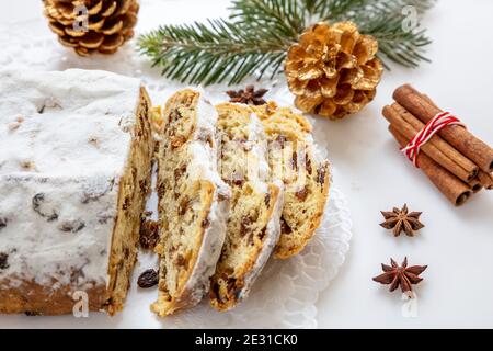 Christstollen fette su sfondo bianco. Dolce natalizio stollen pane tradizionale tedesco dolce, dessert di stagione con uvetta, noci, spezie, fr Foto Stock