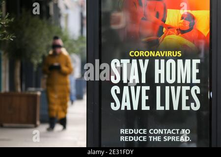 Londra, Regno Unito. 09 gennaio 2021. Una donna oltrepassa il poster della campagna pubblicitaria del governo 'Stay Home, Save Lives' Covid-19 a Londra, poiché il numero di casi della variante mutata del virus SARS-Cov-2 continua a diffondersi in tutto il paese. Credit: SOPA Images Limited/Alamy Live News Foto Stock