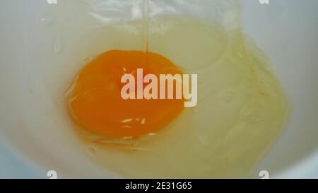 Primo piano immagine con un fresco uovo bianco e tuorlo Preparato per cucinare in cucina per la prima colazione Foto Stock