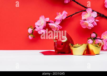 Red Ox Piggy Bank, Sakura Cherry Blossom, Golden ingot e Red Envelope su sfondi bianchi e rossi Foto Stock