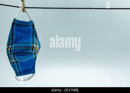 La maschera di stoffa hanging.Hand fatto cotone panno maschera sono l'asciugatura. Maschera per il viso riutilizzabile fatta in casa dopo il lavaggio. Foto Stock