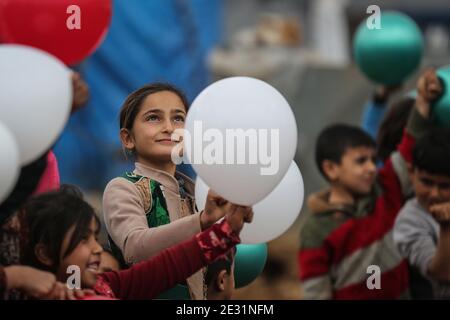 Sarmada, Siria. 16 gennaio 2021. I bambini siriani si acclamano per i concorrenti che partecipano a un concorso sportivo organizzato da volontari nel campo di Baraem per gli sfollati interni. Credit: ANAS Alkharboutli/dpa/Alamy Live News Foto Stock