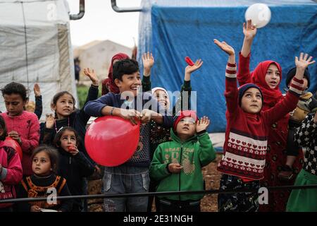 Sarmada, Siria. 16 gennaio 2021. I bambini siriani si acclamano per i concorrenti che partecipano a un concorso sportivo organizzato da volontari nel campo di Baraem per gli sfollati interni. Credit: ANAS Alkharboutli/dpa/Alamy Live News Foto Stock