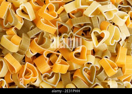 Pasta a forma di cuore di grano duro con verdure per San Valentino. Cibo sfondo. Foto Stock