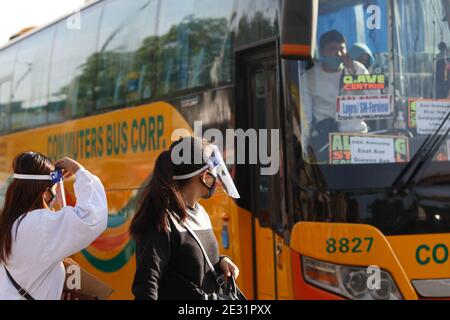 Persone fuori da un autobus lungo Commonwealth Avenue Quezon City. C'è ancora un limite per gli autobus pubblici che sono autorizzati a operare durante la quarantena della comunità generale a Metro Manila, Filippine. Foto Stock