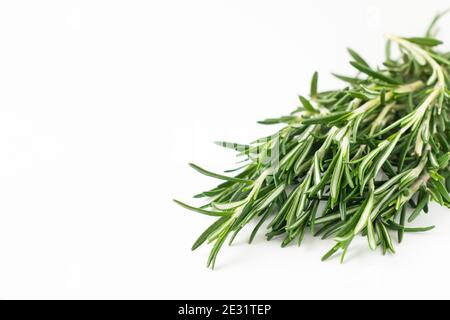 Bouquet fresco di foglie di rosmarino in una ciotola di ceramica bianca su sfondo bianco chiaro. Messa a fuoco selettiva. Foto Stock