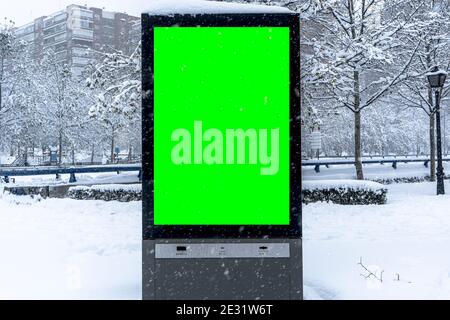Immagine verticale del poster della città città città invernale con bordi spessi, cartellone verde in ambienti urbani, segnaposto informazioni sulla strada vuoto sul marciapiede con Foto Stock