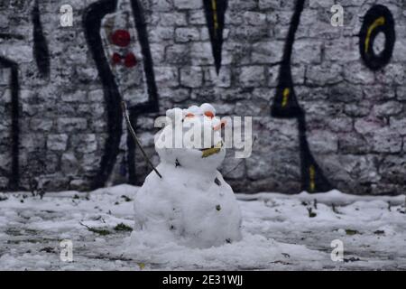 Snowman di fronte al muro di graffiti Foto Stock