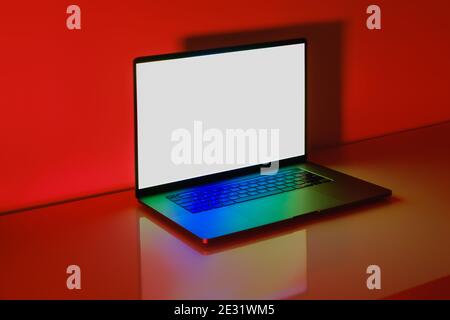Computer portatile moderno con schermo bianco su un tavolo lucido con luce di sfondo rossa brillante Foto Stock